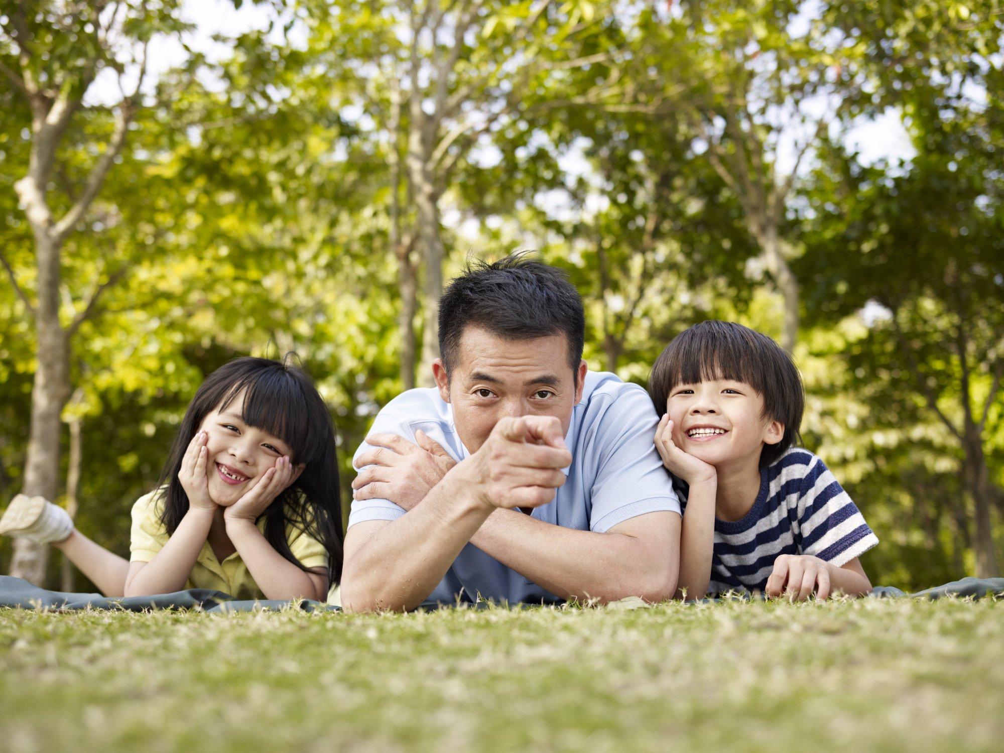 Asian father and children having fun outdoors