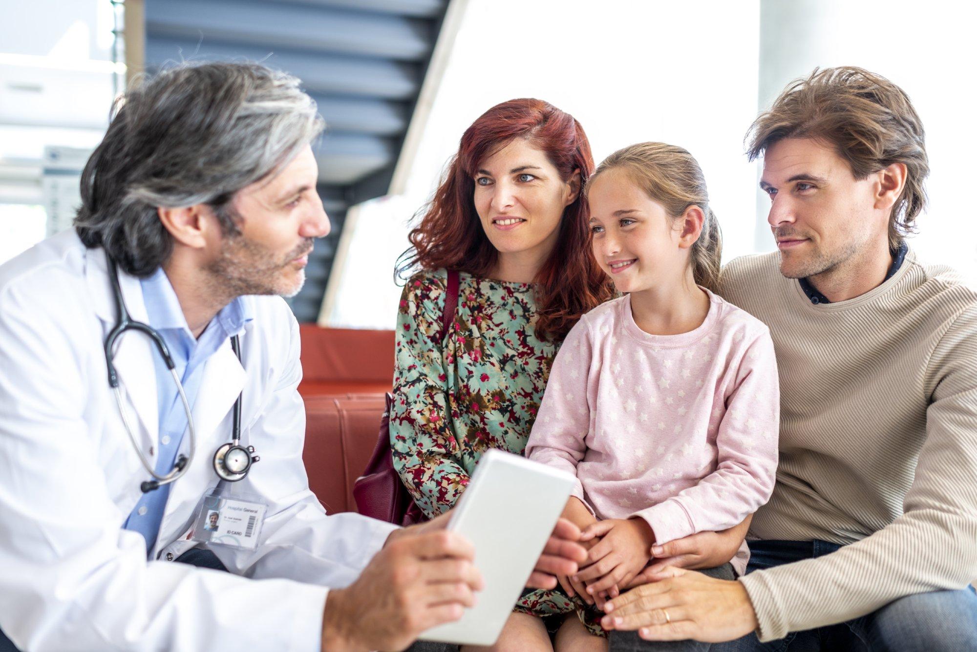 Doctor talks with a young family at hospita