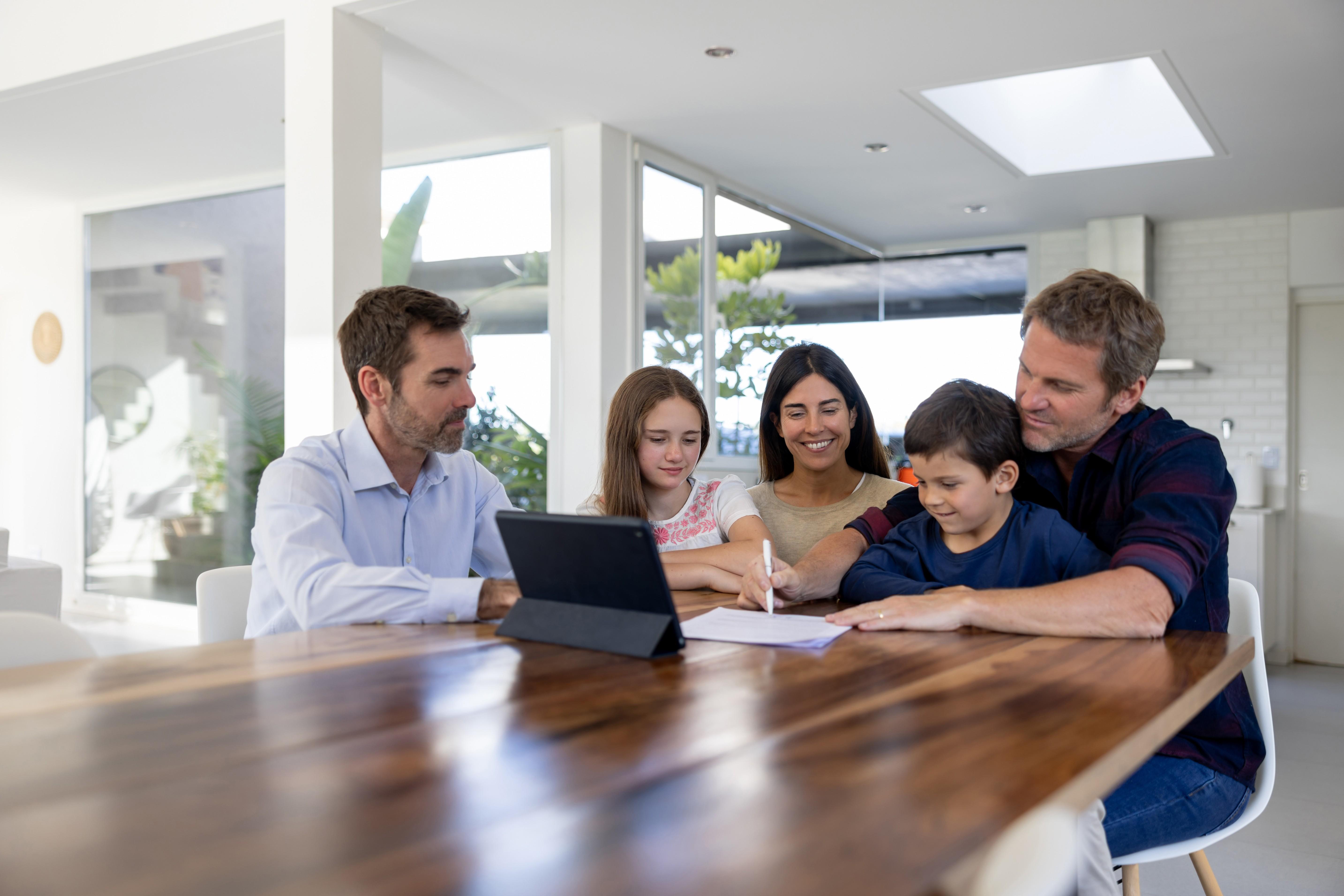 Family buying a house and signing the deed with Real Estate Agent