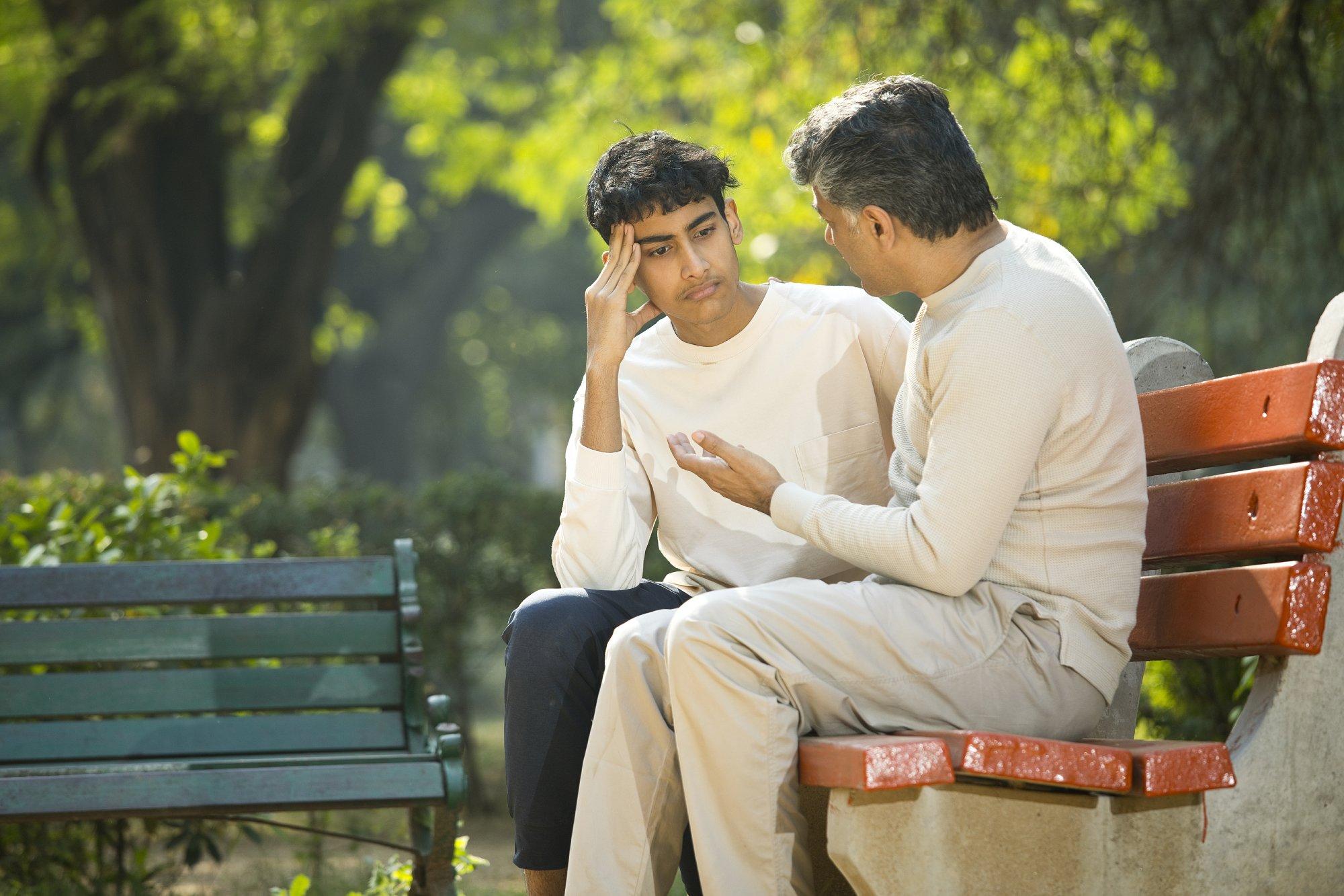 Father comforting his son at park