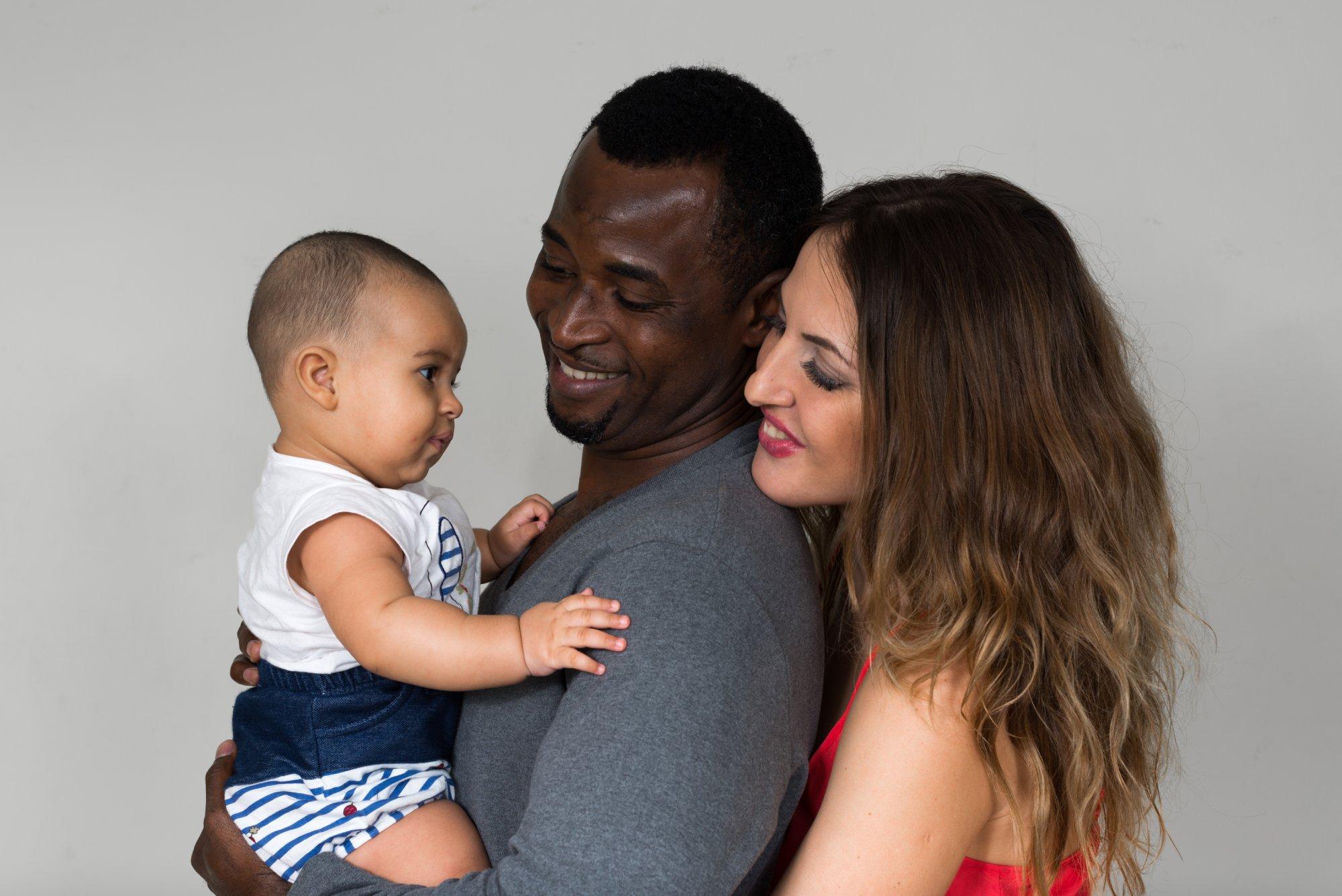 Happy multi ethnic heterosexual couple holding baby girl