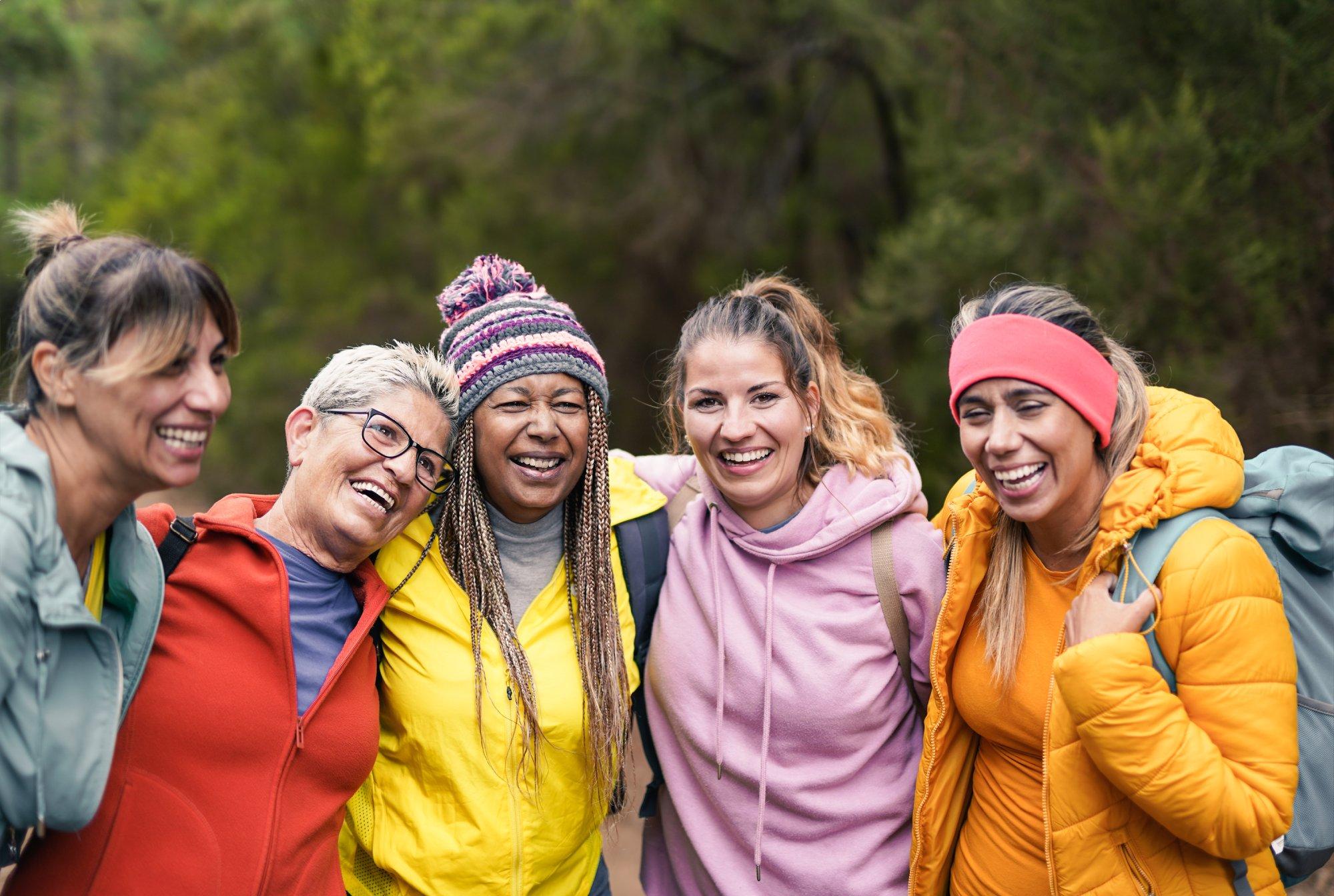 Multi generational women having fun at trekking day - Hiking multiracial friends enjoy day in mountain forest