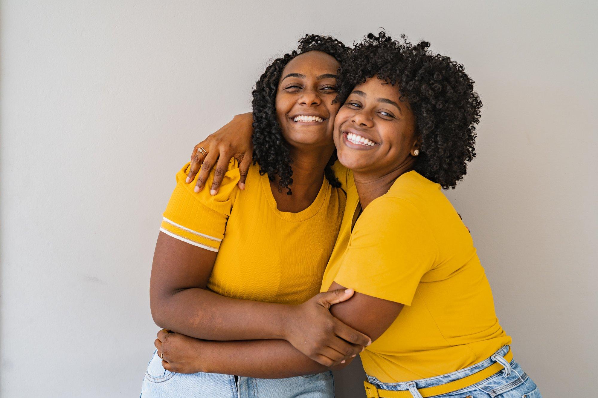 Portrait of two sisters hugging each other smilin