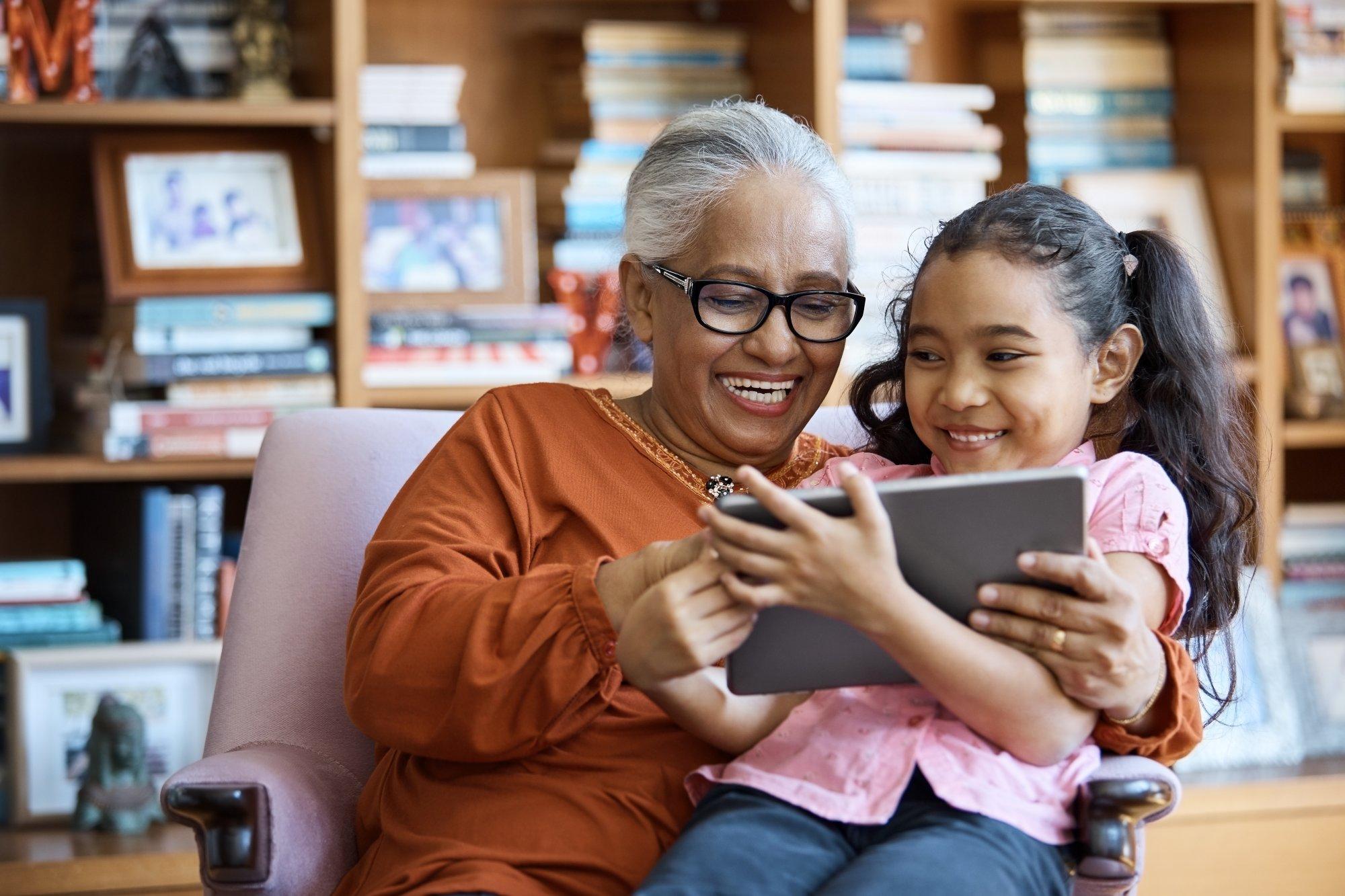 Smiling females using digital tablet at home